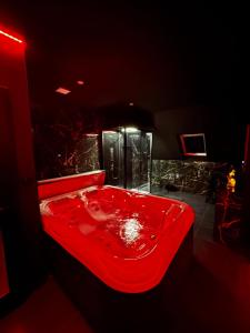 een rode badkuip gevuld met rode vloeistof in een badkamer bij Love room spa in Erstein +1 foto