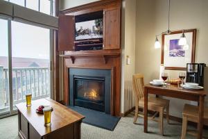 a living room with a fireplace with a tv above it at Allegheny Springs 414: Junior Studio Slopeside in Snowshoe