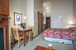 a hotel room with a bed and a desk with a table at Allegheny Springs 414: Junior Studio Slopeside in Snowshoe