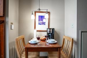 a dining room table with two chairs and a wooden table with glasses at Allegheny Springs 414: Junior Studio Slopeside in Snowshoe