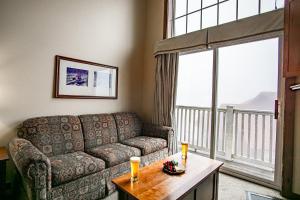 a living room with a couch and a large window at Allegheny Springs 414: Junior Studio Slopeside in Snowshoe