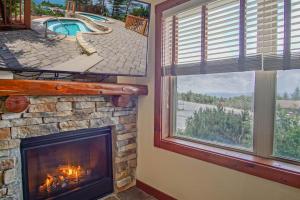 a fireplace in a living room with a view of a pool at Rimfire 151- 152 Unique 2 Br Condo in Snowshoe