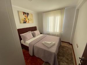 una piccola camera da letto con un letto con una coperta bianca di YELKEN PANSİYON Sinop a Sinope Altre 281 foto