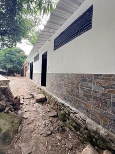 a white house with a brick wall and a window at Villa Esther in El Colegio