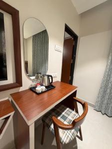 a table with a mirror and a tea kettle on it at MR Suites Dharwad in Dhārwād