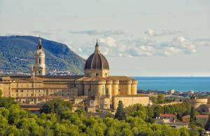 een groot gebouw met een klokkentoren bovenop een stad bij Scossicci Del Sole in Loreto