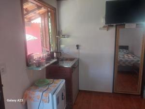 a small kitchen with a sink and a mirror at Morada do Sabiá - chalé 1 in Resende +8 photos