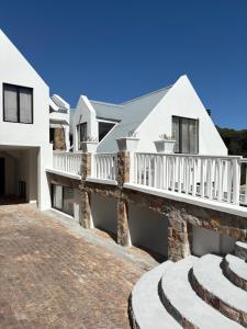 a white house with a balcony and stairs at Providence in Hermanus