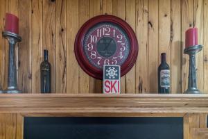 a clock on top of a wooden wall with wine bottles at Powderidge 2 -Slope Side, Spacious Deck in Snowshoe
