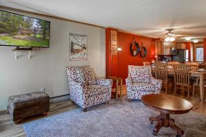 a living room with chairs and a table and a kitchen at Powderidge 2 -Slope Side, Spacious Deck in Snowshoe +23 photos