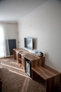 a room with a tv and a wooden entertainment center at The Life Nest Hotel in Saray