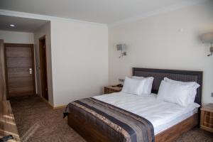 a bedroom with a bed with white sheets and pillows at The Life Nest Hotel in Saray