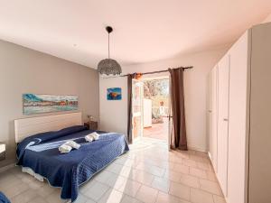 a bedroom with a bed with a blue comforter at Resort Punto Azzurro in Forio d'Ischia +54 photos