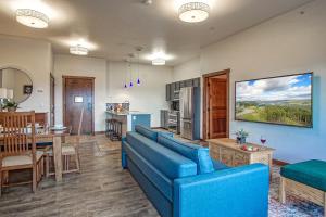 a living room with a blue couch and a kitchen at Soaring Eagle #403: 2 Bedrooms, 2 Full Baths in Snowshoe