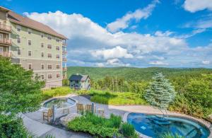 an aerial view of a hotel with a pool and mountains at Soaring Eagle #403: 2 Bedrooms, 2 Full Baths in Snowshoe