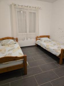 2 letti in una camera con pavimento piastrellato di Logement entier a Montech