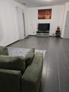 un soggiorno con un divano e una televisione di Logement entier a Montech