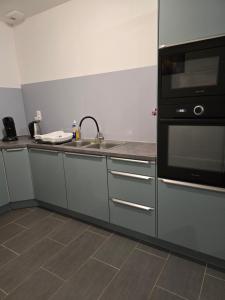 una cucina con lavello e microonde di Logement entier a Montech