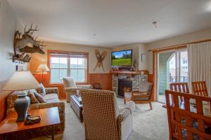 a living room with a couch and a tv at Highland House #102-104: 2Br: 2 Bath in Snowshoe