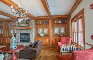 a living room with wood paneling and a fireplace at Highland House #102-104: 2Br: 2 Bath in Snowshoe +34 photos