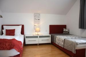 阿特湖畔翁特拉赫洛茵德尔公寓酒店的一间卧室，有两张床和一张带灯的桌子