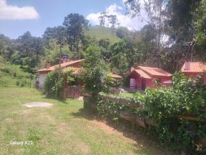 a house with a fence in front of it at Morada do Sabiá - chalé 1 in Resende