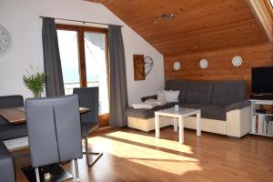 阿特湖畔翁特拉赫洛茵德尔公寓酒店的客厅里有一张沙发和一张桌子。