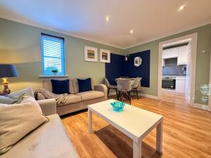 een woonkamer met een bank en een tafel bij GF flat sleeps 4, parking for Contractors by Eagle Owl Stays in Crawley