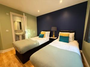 twee bedden naast elkaar in een kamer bij GF flat sleeps 4, parking for Contractors by Eagle Owl Stays in Crawley