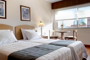 a bedroom with a bed and a table and a window at Salto Grande Hotel in Punta del Este +28 photos