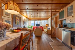 a kitchen and living room with a table and chairs at Residenza Bagni & Miramonti in Cavalese