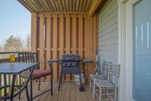 a grill on a deck with a table and chairs at Summit 107B 3Br Condo in Snowshoe