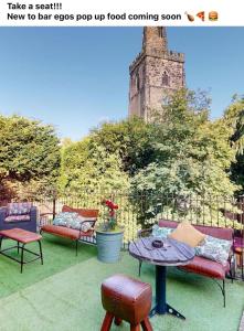 een patio met banken en een tafel en stoelen bij Egos in Castle Donington