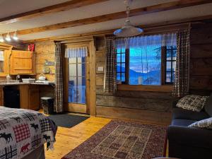 a room with a bed and a kitchen with windows at Nakiska Bear Ranch in Clearwater
