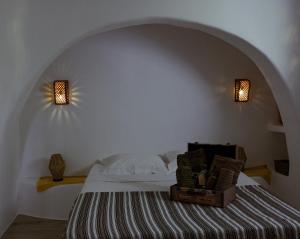 a bedroom with a bed with two lights on the wall at Villa Xanthos in Plaka