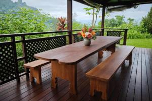 a wooden table and benches on a wooden deck at Uupa Bird Cottage in Moorea
