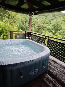 a large hot tub sitting on a deck at Uupa Bird Cottage in Moorea +3 photos