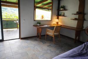 a bedroom with a desk and a table and a chair at Uupa Bird Cottage in Moorea