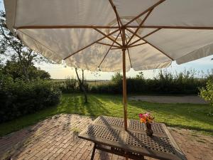 a table with an umbrella on a brick patio at Eulennest in Reimershagen
