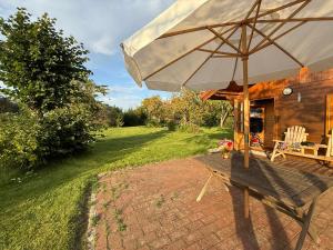 a patio with an umbrella and a table and chairs at Eulennest in Reimershagen +6 photos