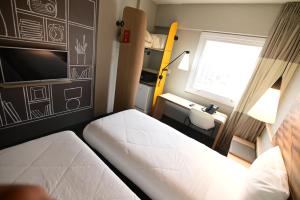 a small room with two beds and a window at ibis Natal in Natal