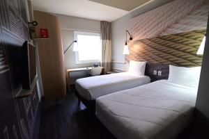 a hotel room with two beds and a flat screen tv at ibis Natal in Natal +79 photos