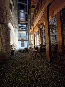 una stanza con un edificio in pietra con un tavolo e delle panche di Hotel Chalet d'Oulx a Oulx