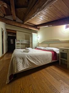 una camera da letto con un letto grande e un pavimento in legno di Hotel Chalet d'Oulx a Oulx