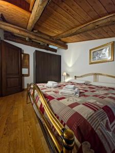 a large bed in a room with a wooden ceiling at Hotel Chalet d'Oulx in Oulx