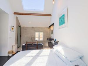 a bedroom with a white bed and a bathroom at Bredy Cottages in Bridport