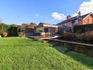 a glass house in the middle of a yard at Bredy Cottages in Bridport