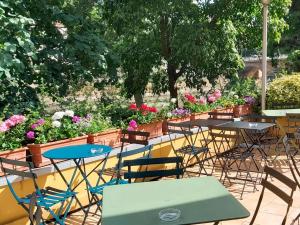 eine Gruppe von Tischen und Stühlen in einem Garten mit Blumen in der Unterkunft ibis Metz Centre Cathedrale in Metz