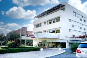 a white building with a car parked in front of it at Salto Grande Hotel in Punta del Este
