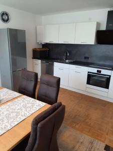 a kitchen with a table and chairs and a kitchen with white cabinets at Ferienwohnung Schabmüller in Kelheim